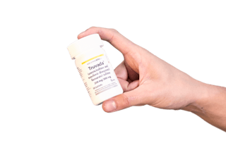 A person holding a white bottle labeled