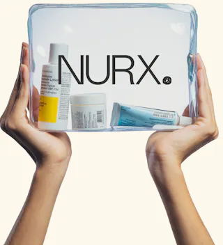 Hands holding a clear pouch with various skincare bottles and containers, labeled 