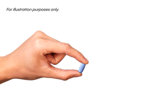 A hand holding a small blue pill between the thumb and index finger against a plain background.