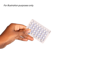 A person holds a blister pack of pills against a white background.