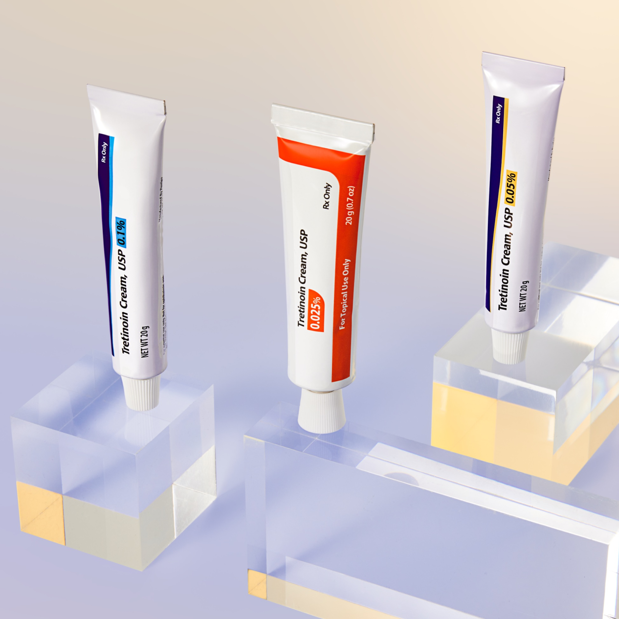 Three tubes of Tretinoin Cream USP with varying strengths grace clear acrylic blocks, set against a gradient backdrop.