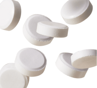 White round tablets scattered on a plain background