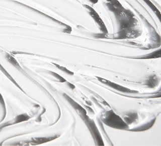 A close-up of clear gel with smooth, swirling patterns and small bubbles evokes the elegance of Tretinoin Cream, capturing its silky texture and precision.
