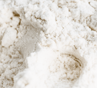 Close-up of a pile of white flour with a slightly textured surface, reminiscent of the fine consistency often associated with Tretinoin Cream.