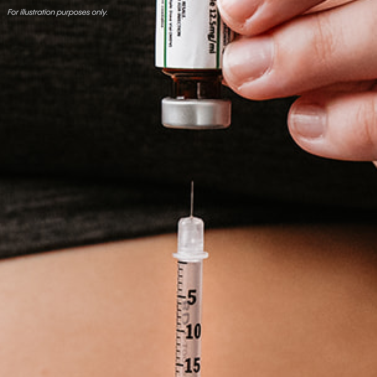 A person holds a vial and fills a syringe with liquid medication.