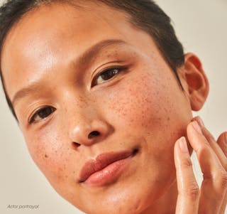 Women touches her face with glowing skin.