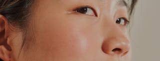 Close-up of a person's face focusing on the eyes, cheek, and nose, showing smooth skin and natural features.
