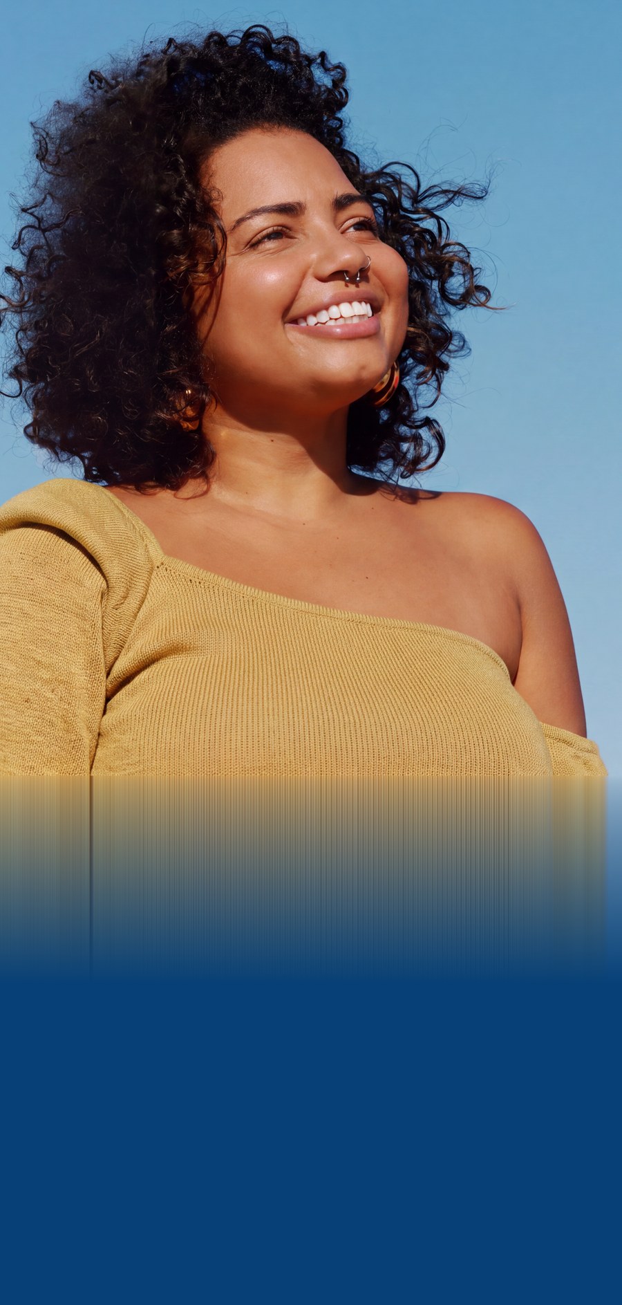 Smiling person outdoors against a blue sky